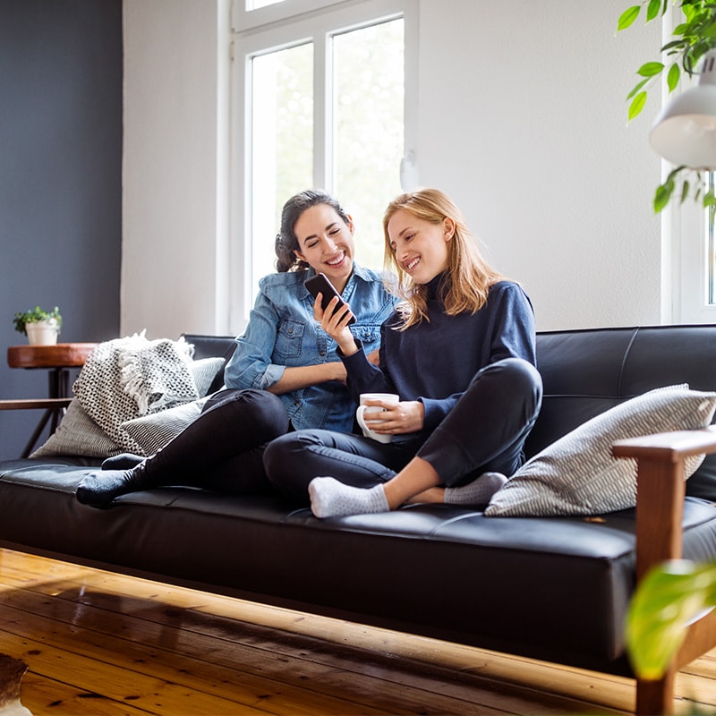 2 women sitting on couch and chatting